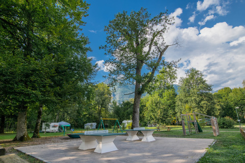 Udendørs legeplads og bordtennisborde på Onlycamp Camping Les Thézières i Auvergne-Rhône-Alpes, Frankrig.