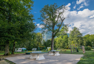 Udendørs legeplads og bordtennisborde på Onlycamp Camping Les Thézières i Auvergne-Rhône-Alpes, Frankrig.