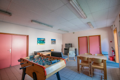 Gemeenschappelijke ruimte bij Onlycamp Camping Les Thézières met een tafelvoetbaltafel en zitgedeelte.