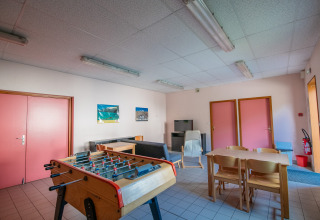 Fællesrum på Onlycamp Camping Les Thézières med bordfodbold, sofaer og spisebord i Auvergne-Rhône-Alpes.