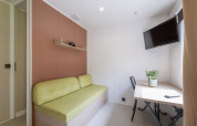 Interno moderno di una Static caravan Comfort a Seasonova Camping Le Plan d’Eau, Francia, con divano e scrivania.