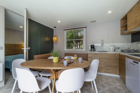Modern kitchen and dining space in Mobile home Confort at Seasonova Camping Le Plan d’Eau in France.