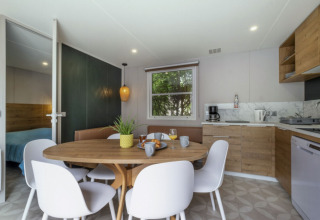 Modern kitchen and dining space in Mobile home Confort at Seasonova Camping Le Plan d’Eau in France.