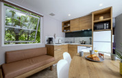 Cocina y comedor modernos en Mobile home Confort de Seasonova Camping Le Plan d’Eau, Francia, con muebles de madera.