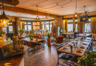 Acogedor comedor de lodge con muebles de madera rústica, grandes ventanales y luz cálida y decorativa.
