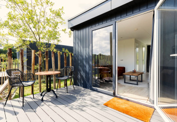 Terrasse moderne avec deux chaises et une table devant un tiny house à De Kremmer, Pays-Bas.