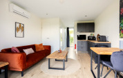 Modern interieur van Tiny House bij De Kremmer in Nederland met comfortabele bank en compacte keuken.
