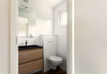 Petite salle de bain moderne avec WC suspendu et meuble bois au Tiny House à De Kremmer, Pays-Bas.