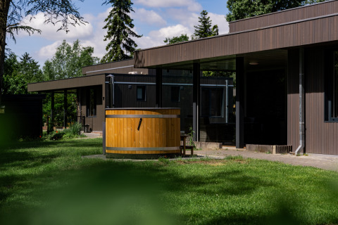 Boslodge Plus met hottub bij vakantiecentrum 't Schuttenbelt in Nederland, moderne houten lodge met tuin.