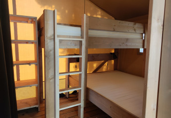 Indretning af Lodgetent-safaritelte på Camping Luna del Monte i Italien, med køjesenge i træ.