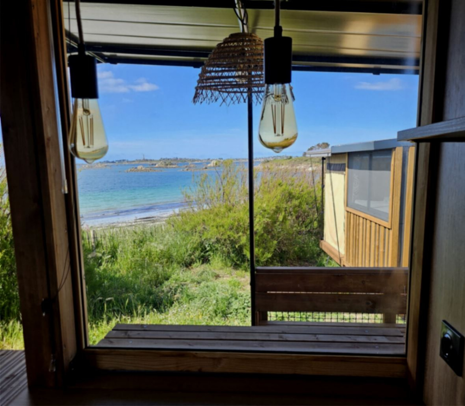 Uitzicht vanuit een safaritent bij Camping Seasonova La Pointe de Roscoff in Frankrijk op zee en strand.
