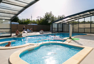 Hallenbad mit klarem Wasser, entspannte Gäste und Sonnenlicht im Seasonova Camping Le Brabois, Grand Est, Frankreich.