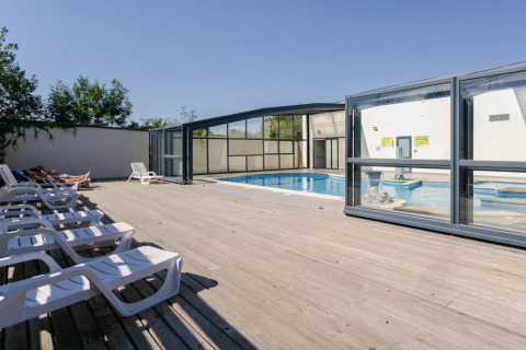Außenpool mit Liegestühlen und überdachtem Schwimmbad im Seasonova Camping Le Brabois in Grand Est, Frankreich.