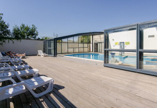 Espace piscine extérieure avec transats et bassin couvert au Seasonova Camping Le Brabois en Grand Est, France.