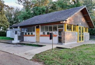 Modernes Sanitärgebäude bei Seasonova Camping Le Brabois in Grand Est, Frankreich, von Grün umgeben.