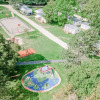 Aerial view of Seasonova Camping Le Brabois in Grand Est, France with playground, sports courts, and lodges.