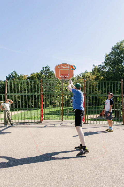 Menschen spielen Basketball im Freien im Ferienpark Seasonova Camping Le Brabois in Grand Est, Frankreich.