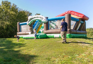 Des enfants jouent sur une structure gonflable sous le soleil au Seasonova Camping Le Brabois, Grand Est