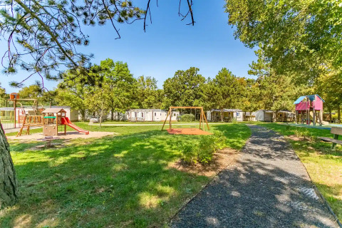 Playground and green spaces at Seasonova Camping Le Brabois holiday park in Grand Est, France.