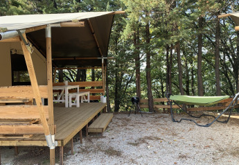 Safari-teltet Lodgetent på Campsite Luna del Monte i Italien med veranda, hængekøje og skovudsigt.