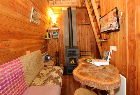 Gemütliches Tiny House 'Van Gogh' bei De Wije Werelt, Niederlande, mit Holzofen und Holzwänden.