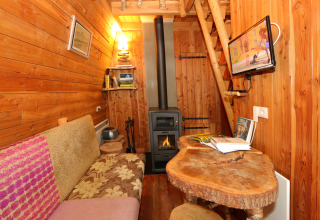 Gemütliches Tiny House 'Van Gogh' bei De Wije Werelt, Niederlande, mit Holzofen und Holzwänden.