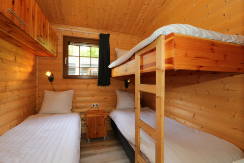 Holzzimmer mit Etagenbett und Einzelbetten in der Boekhorst-Lodge bei De Wije Werelt, Niederlande.