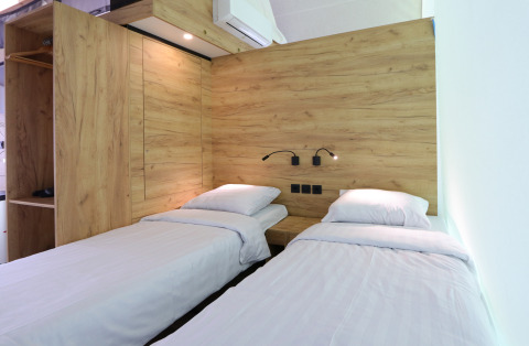 Interior view of a glamping tent at De Wije Werelt, Netherlands, showing twin beds and modern wood decor.