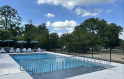 Outdoor swimming pool with lounge chairs and umbrellas at Camping Vauban, Grand Est, France on a sunny day.