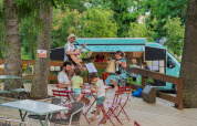 En musikalsk liveoptræden på terrassen i Camping Vauban i Grand Est, Frankrig, med gæster og en foodtruck.