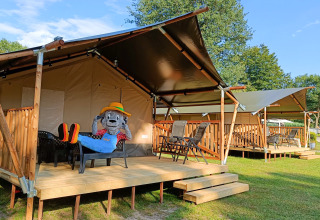 Safari-Zelte mit Holzterrasse auf dem Campingplatz De Rammelbeek, Overijssel, Niederlande, Maskottchen sitzt.