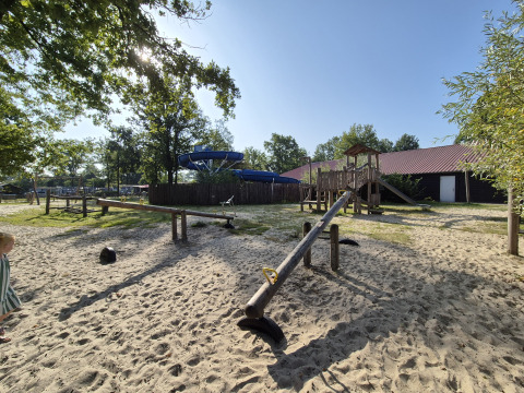 Spielplatz mit Wippe, Kletterturm und Sand auf dem Campingplatz De Rammelbeek in Overijssel, Niederlande.