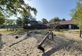 Spielplatz mit Wippe, Kletterturm und Sand auf dem Campingplatz De Rammelbeek in Overijssel, Niederlande.