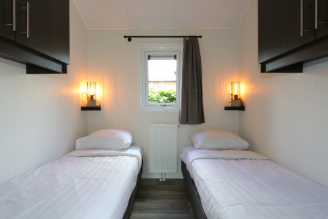 Habitación moderna en la cabaña Velthorst, De Wije Werelt, Países Bajos, con dos camas individuales.