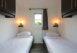 Habitación moderna en la cabaña Velthorst, De Wije Werelt, Países Bajos, con dos camas individuales.