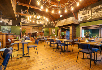 Interno di ristorante accogliente con pavimento in legno e decorazioni in Tiny House 4, Beekbergen, Paesi Bassi.