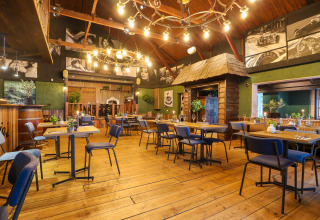 Warm restaurant interior with wooden floors and unique decor inside Tiny House 4, Beekbergen, Netherlands.