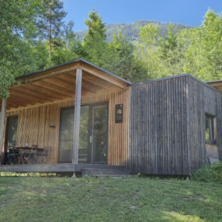 Glamping lodge ved Seecamping Kleblach-Lind i Karinthië, omgivet af træer og natur, med udendørs terrasse.