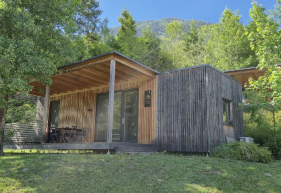 Glamping lodge ved Seecamping Kleblach-Lind i Karinthië, omgivet af træer og natur, med udendørs terrasse.