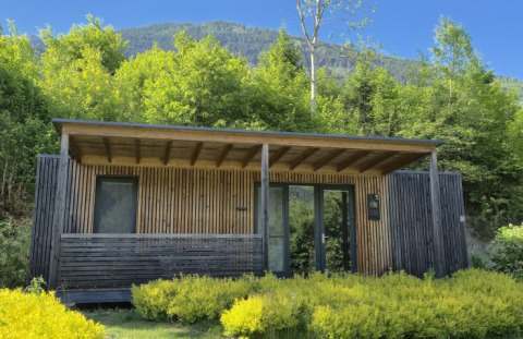 Moderne glamping lodge på Seecamping Kleblach-Lind i Kärnten omgivet af frodig natur og bjerge.