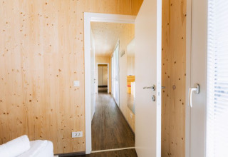 Bright wooden interior of a glamping lodge at Seecamping Kleblach-Lind in Carinthia, with open door view.