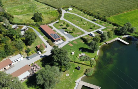 Luftfoto af Seecamping Kleblach-Lind – Lodges Karinthië med campingplads, sø og grønne områder.