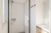 Moderne badkamer in een stacaravan bij Seasonova Camping Le Plan d’Eau, Frankrijk, met douche en wasbak.