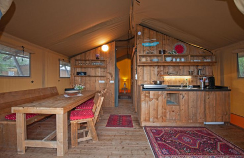 Interno di una tenda glamping presso Inselcamping Kollersee – Safaritenten Rijnland-Pfalz con cucina in legno.