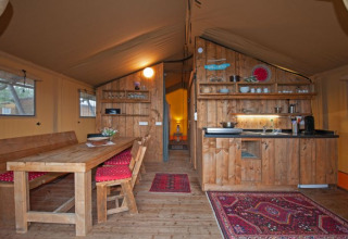 Interieur van een safaritent op Inselcamping Kollersee – Safaritenten Rijnland-Pfalz met keuken en eethoek.
