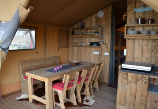 Gezellige glamping accommodatie met rustiek houten interieur en eetruimte bij Inselcamping Kollersee – Safaritenten Rijnland-Pfalz.