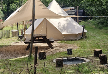 Basecamp Bell tent op Thuysgrond in Nederland met vuurkorf, picknicktafel en groene omgeving.