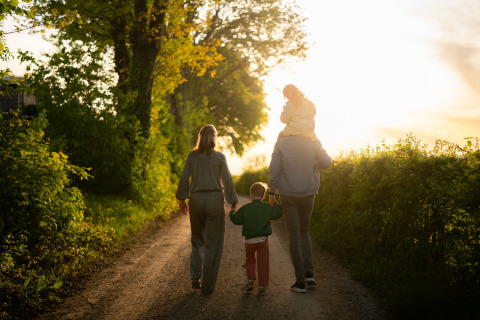 Una familia camina por un sendero al atardecer cerca de su alojamiento glamping, disfrutando de la naturaleza.
