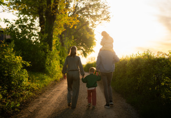 Una familia camina por un sendero al atardecer cerca de su alojamiento glamping, disfrutando de la naturaleza.