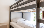 Modern bunk bed in a bright room with wood flooring and art at Schaelsbergerbosch - Garden House &.